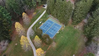Aerial view of tennis court with path beside it