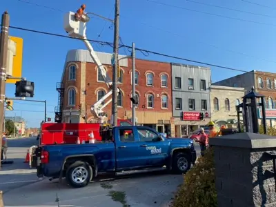 Person in bucket lift above Owen Sound truck installing camera