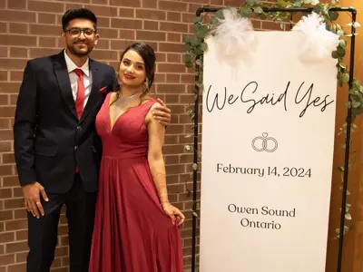 Bride and groom beside sign that says 'we said yes'